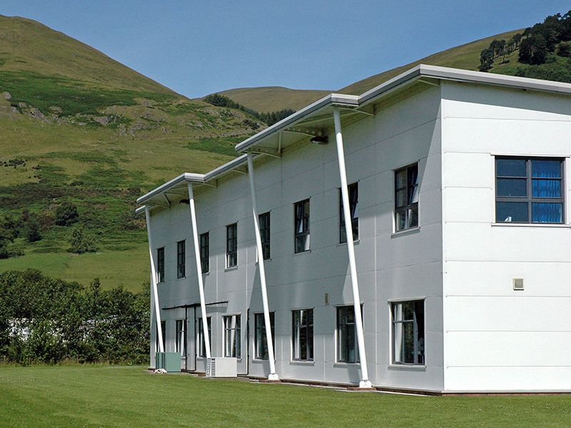 White modern office building set agains the green Ochil Hills in Central Scotland